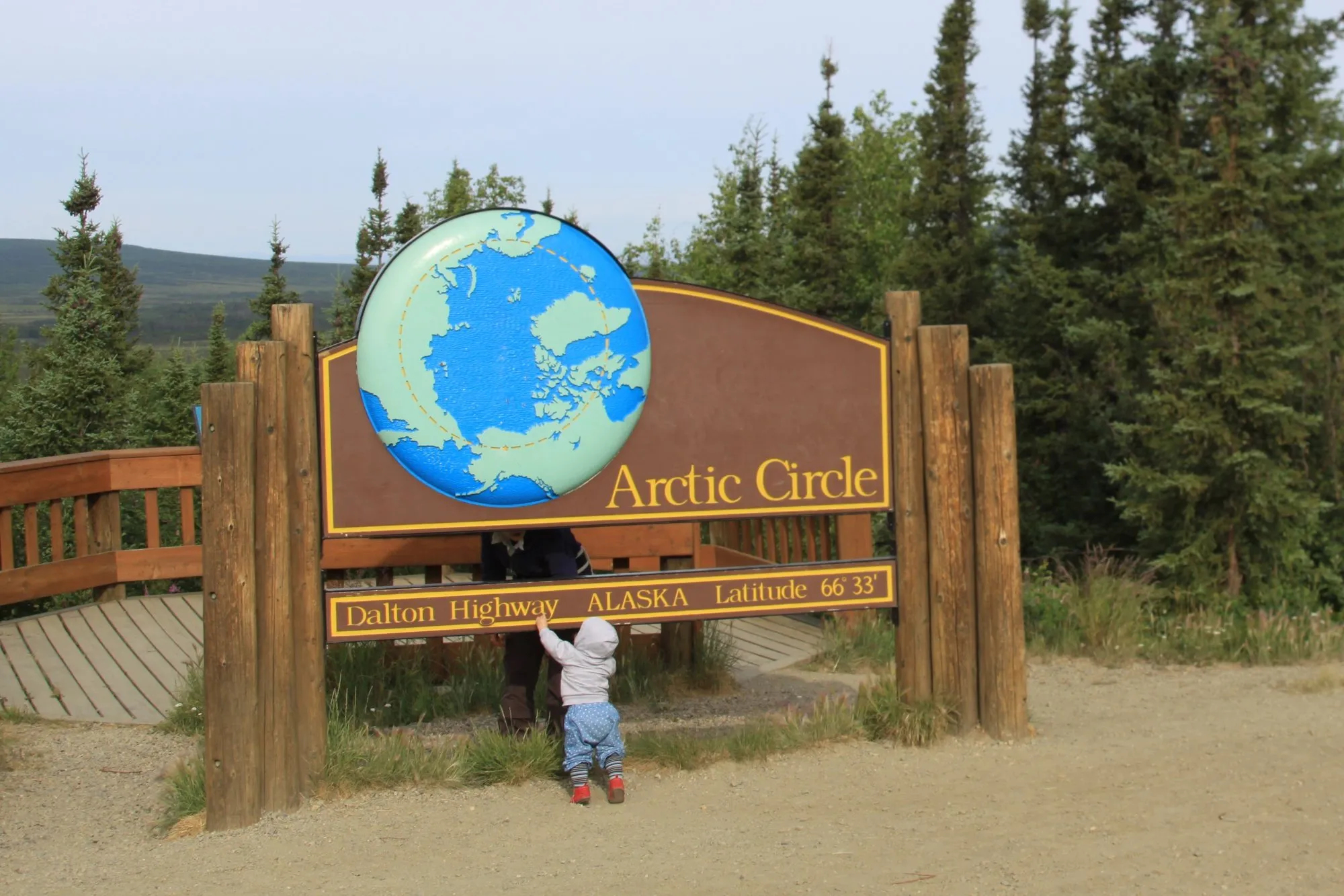 The wooden Arctic Circle sign with a globe on the Dalton Highway