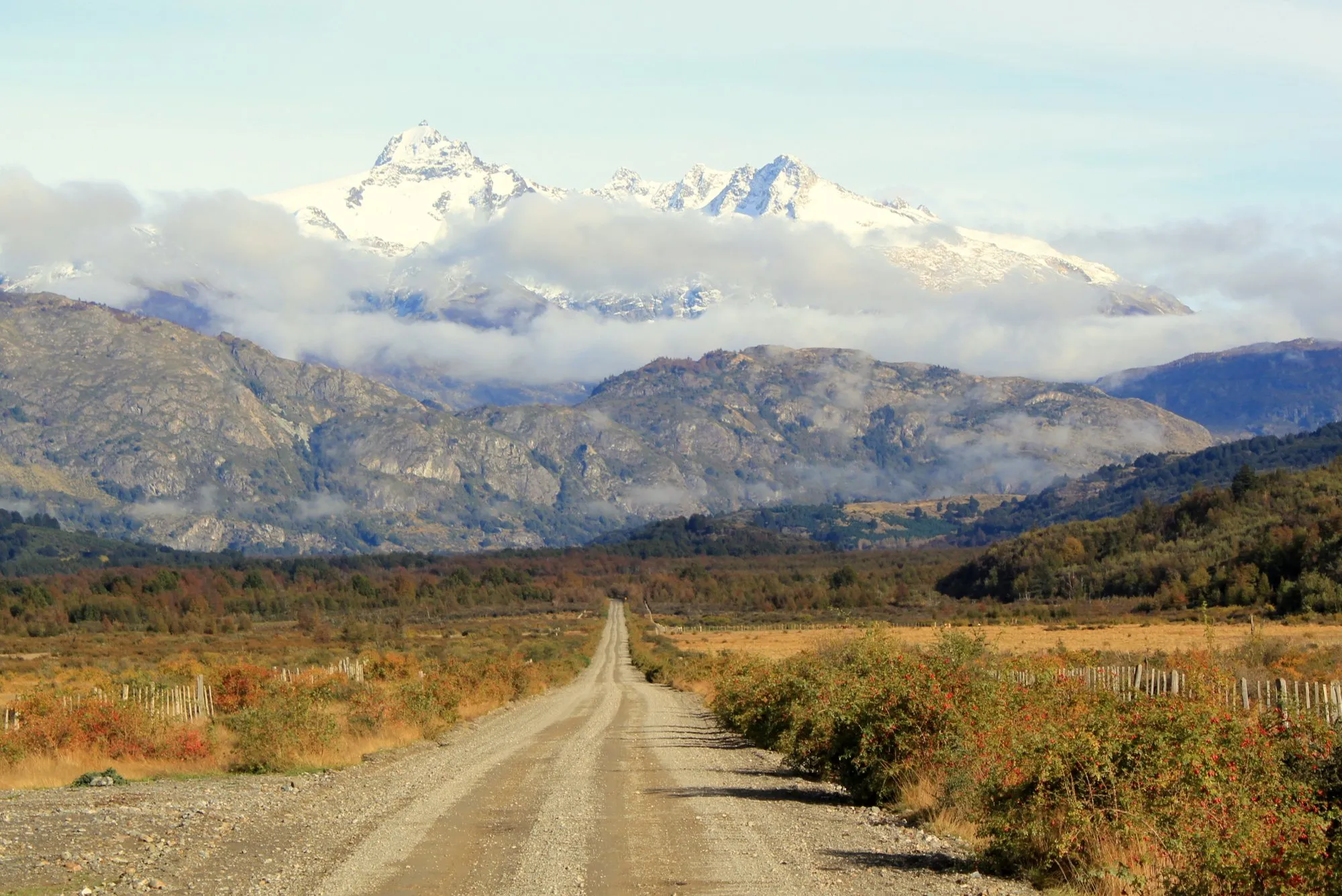 A gravel stretch of the Carretera Austral running towards snow-capped Patagonian peaks