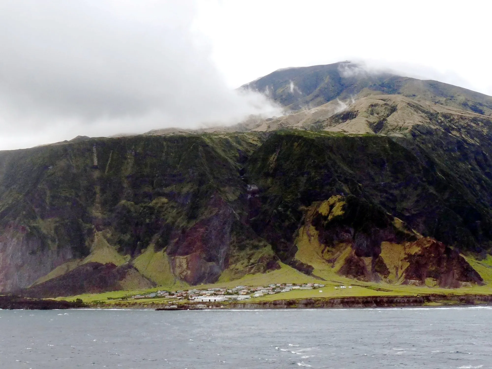 Edinburgh of the Seven Seas on a green coastal plain beneath the cliffs of Tristan da Cunha