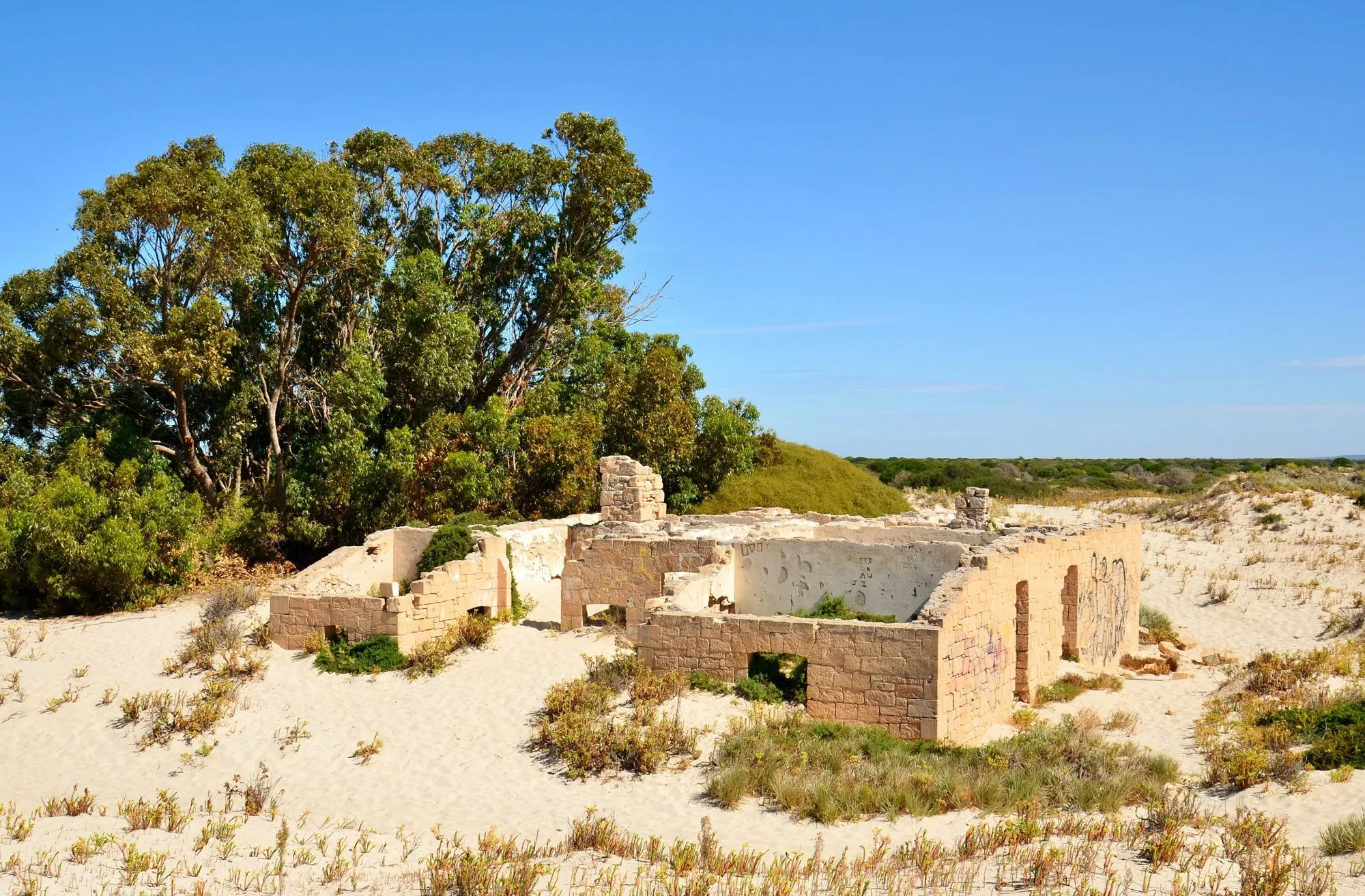 Ruined stone walls of the Eucla Telegraph Station among sand dunes