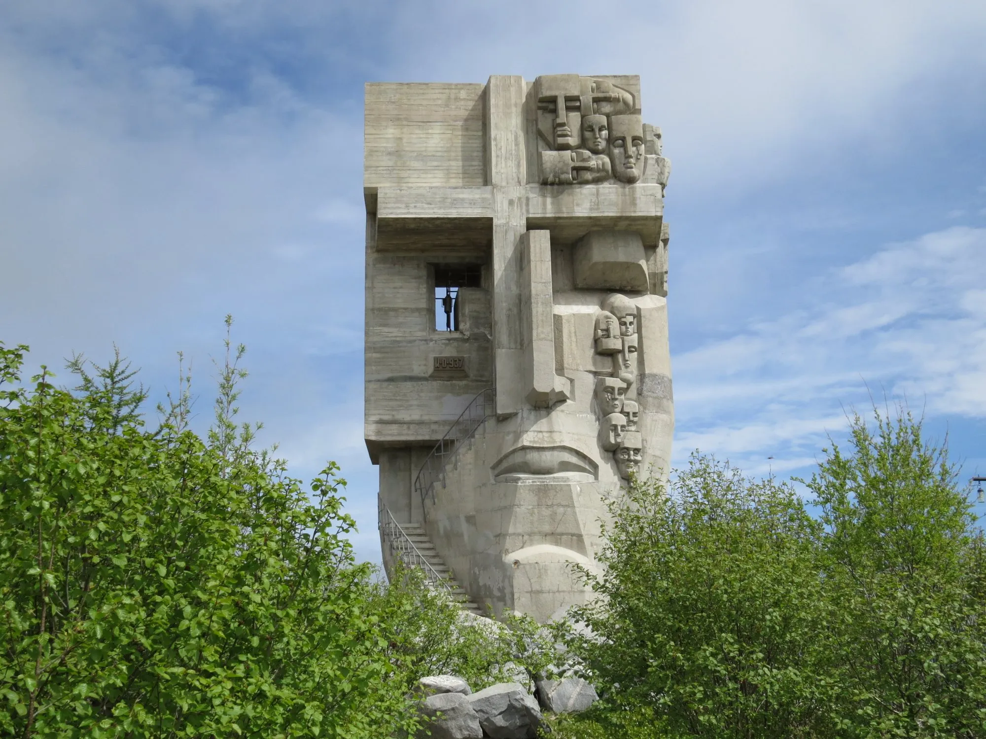The concrete Mask of Sorrow memorial with sculpted faces, on a hill in Magadan