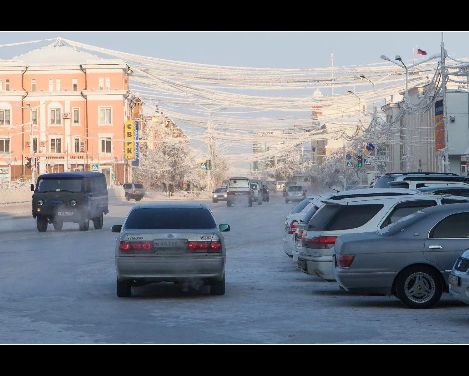 Cars on a frosty street in Yakutsk with ice-coated power lines overhead