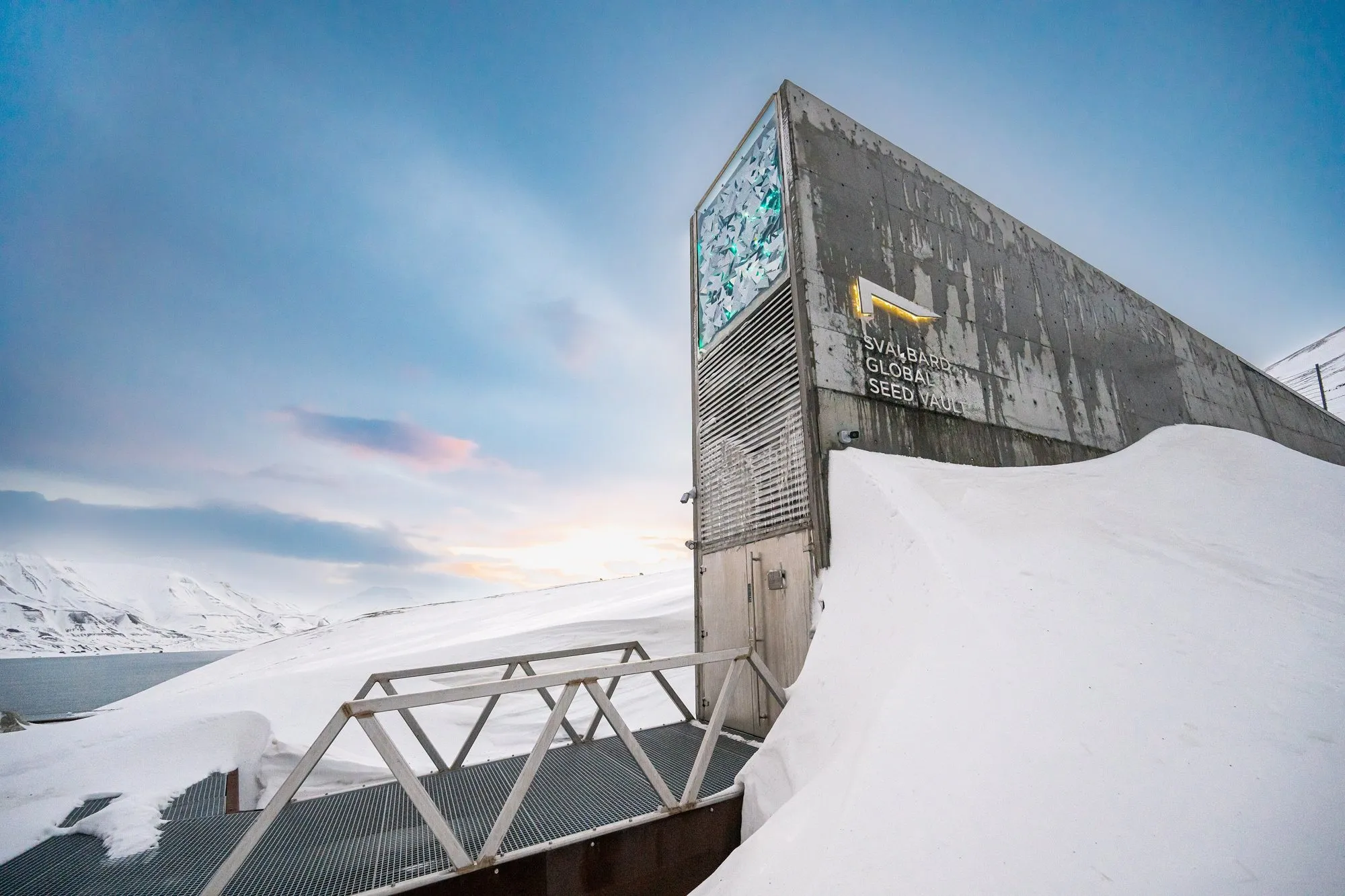 The angular concrete entrance of the Svalbard Global Seed Vault half buried in snow