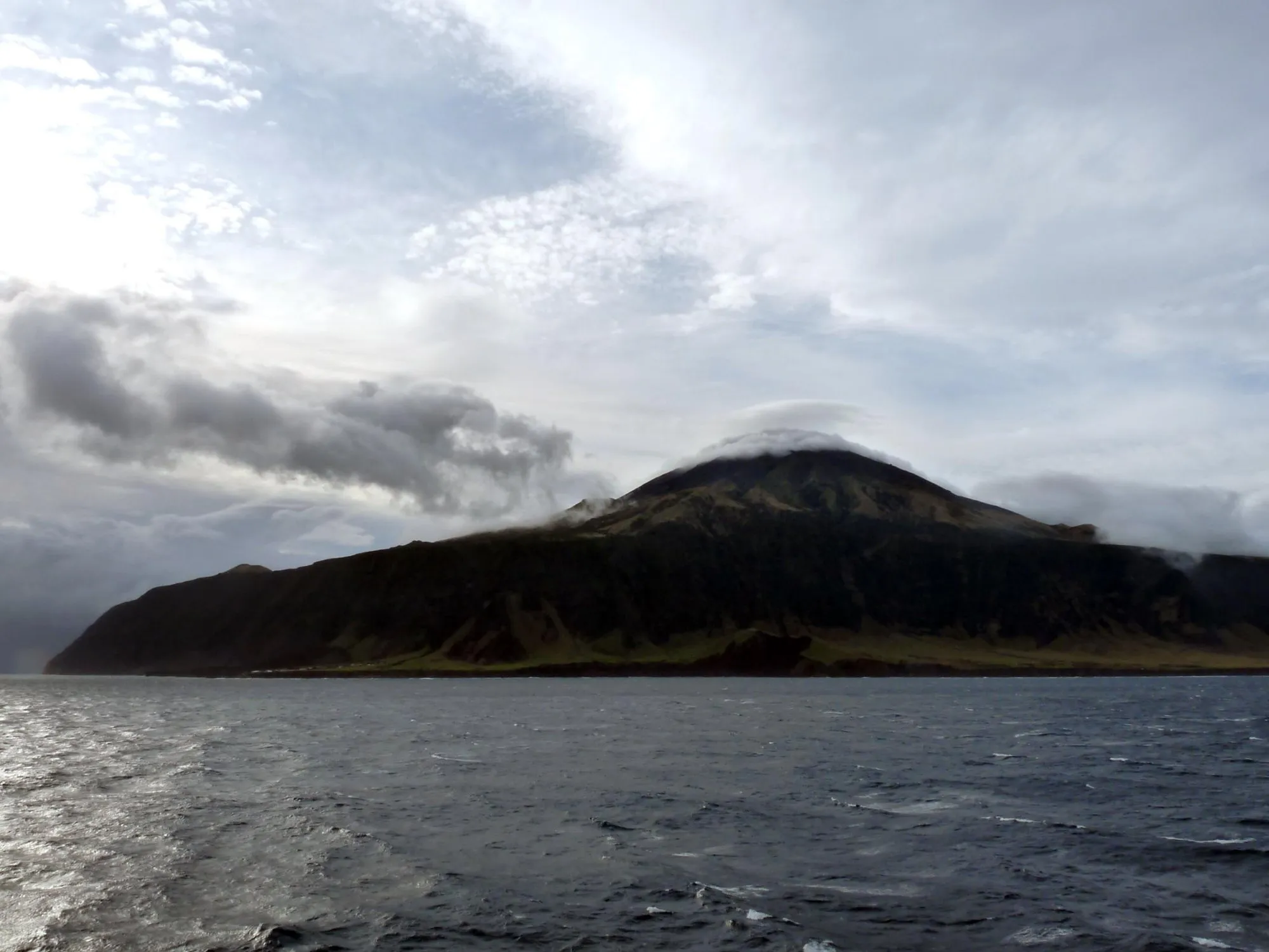 The dark cone of Tristan da Cunha under cloud, seen from a ship