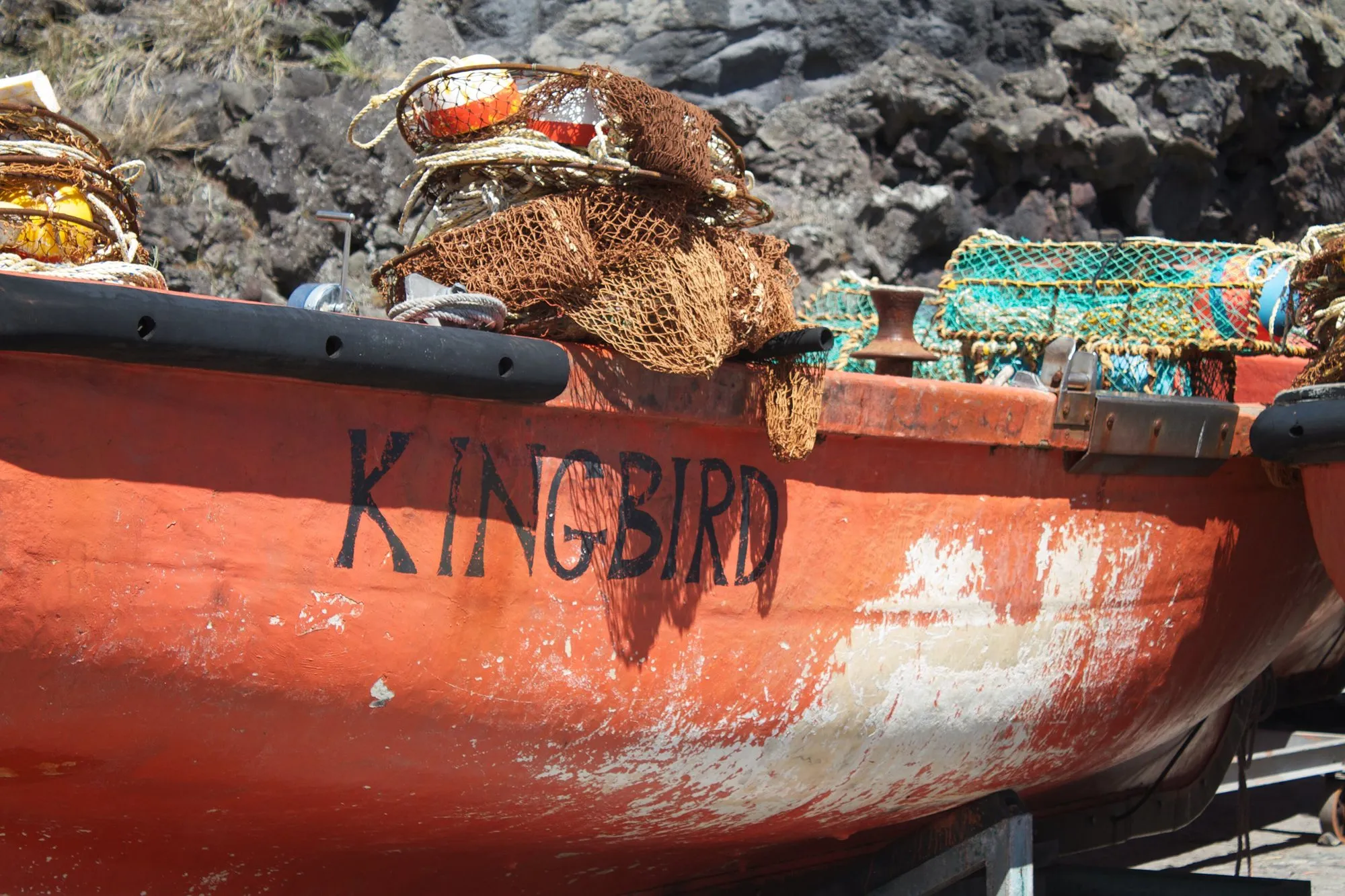 A red wooden longboat named Kingbird loaded with lobster traps