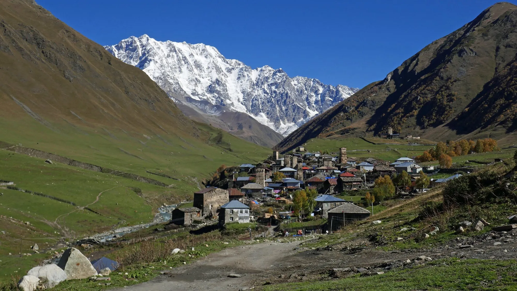 Ushguli village in a valley below the snow-covered Shkhara massif